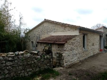 Restauration des pierres et poutres en bois d’une grange réhabilitée.