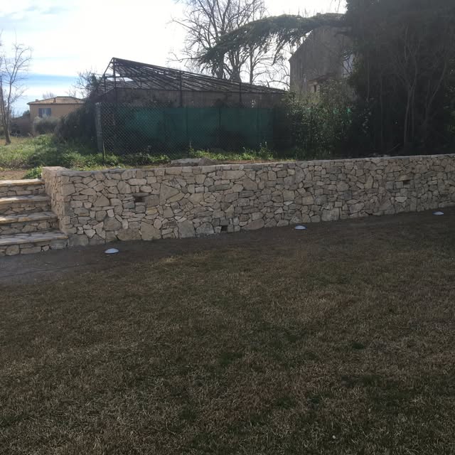 Mur de soutènement en pierre naturelle construit par LLH Construction.